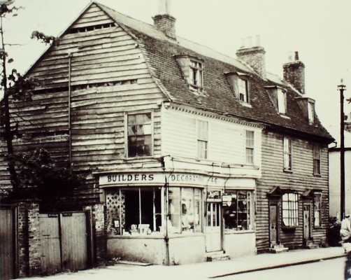 Timber-clad buildings on the east side, in front of the modern car park, 1959